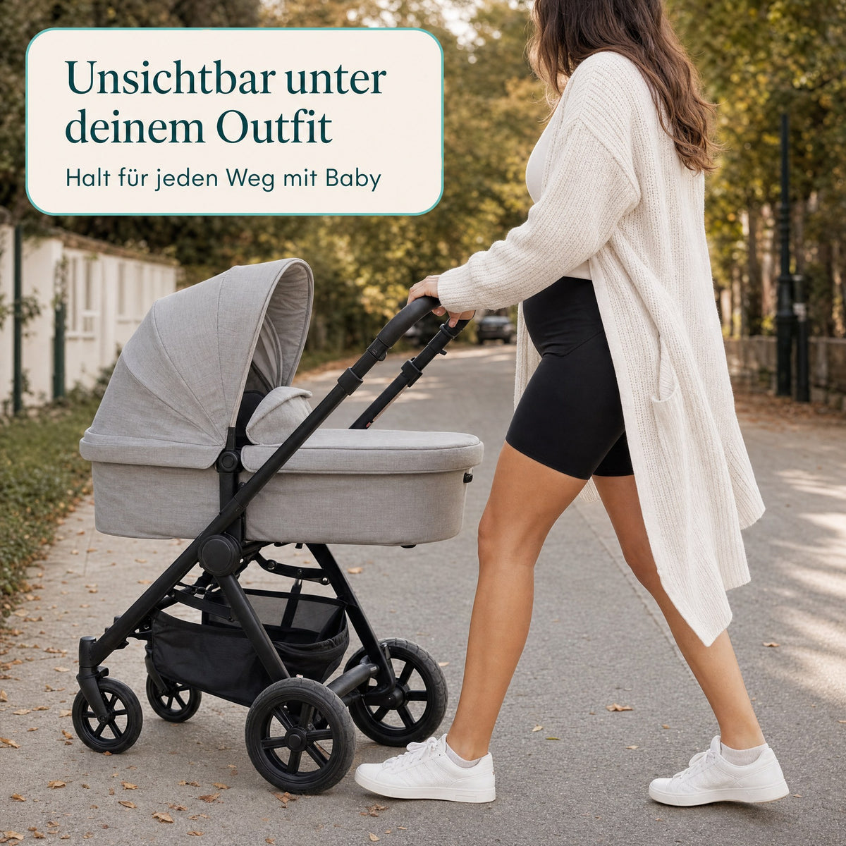 MamaFlex in Schwarz unter einer langen Strickjacke beim Spaziergang mit Kinderwagen