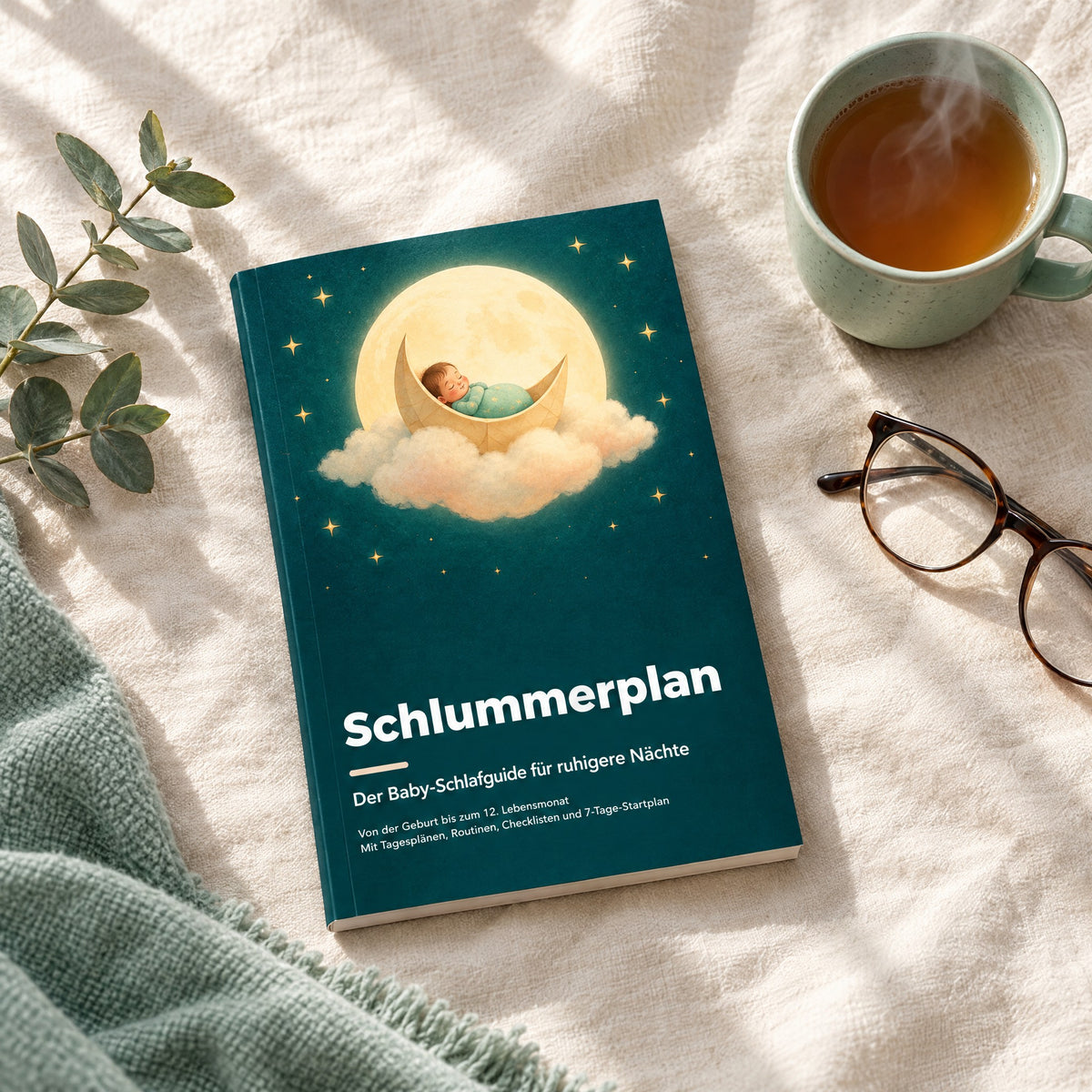 Schlummerplan Baby-Schlafguide auf einer Leinendecke neben einer Tasse Tee